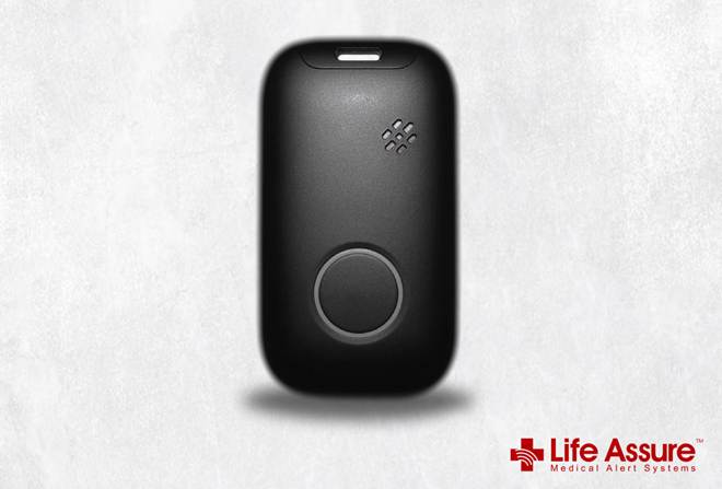 A black rounded rectangular alert device with a round button, speaker holes and a charging port, shown upright against a pale marbled background with the Life Assure logo